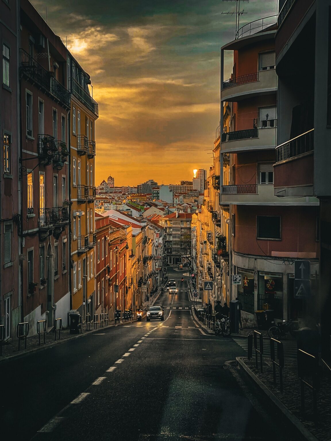 Calle de Lisboa descendiendo hacia la ciudad bajo una luz dorada